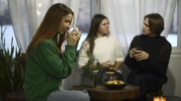 studenten praten en kom tot rust in knus cafe. media. mooi jong vrouw is drinken thee Aan achtergrond van pratend paar. studenten kom tot rust en drinken thee in college cafe foto