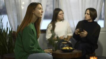 studenten praten en kom tot rust in knus cafe. media. mooi jong vrouw is drinken thee Aan achtergrond van pratend paar. studenten kom tot rust en drinken thee in college cafe foto