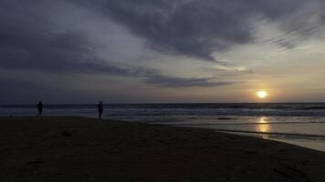 dramatisch zee zonsopkomst Aan bewolkt lucht. actie. golvend zand zee schoen en een paar vergadering nieuw dag. foto