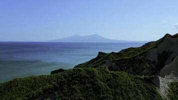 adembenemend antenne visie van dramatisch groen bergen en blauw oceaan. klem. mooi natuur achtergrond van groen oerwoud berg pieken onthullend turkoois water oppervlak. foto