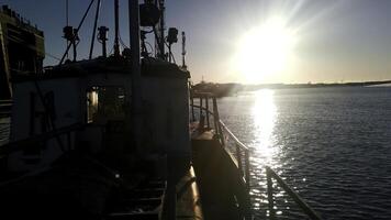 een visie van een aak schip vervoeren goederen. klem. schip Aan kabbelend rivier- met schijnend zon Aan de achtergrond. foto