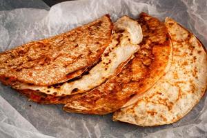 huisgemaakte Mexicaanse quesadilla is gestapeld op een perkament. foto
