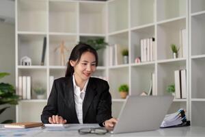 jong bedrijf vrouw Aziatisch of werknemer accounting boekhouding documenten controle financieel gegevens of afzet verslag doen van werken in kantoor met laptop. papierwerk beheer foto