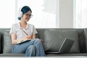 gelukkig jong vrouw tiener- vervelend hoofdtelefoons schrijven Opmerking. leerling online aan het leren klasse studie online video telefoontje zoom leraar met laptop en boek foto