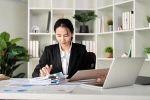 jong bedrijf vrouw Aziatisch of werknemer accounting boekhouding documenten controle financieel gegevens of afzet verslag doen van werken in kantoor met laptop. papierwerk beheer foto