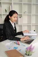 jong bedrijf vrouw Aziatisch of werknemer accounting boekhouding documenten controle financieel gegevens of afzet verslag doen van werken in kantoor met laptop. papierwerk beheer foto