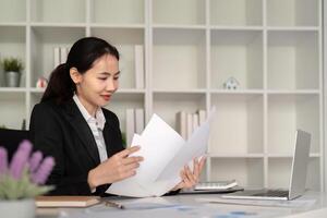 jong bedrijf vrouw Aziatisch of werknemer accounting boekhouding documenten controle financieel gegevens of afzet verslag doen van werken in kantoor met laptop. papierwerk beheer foto