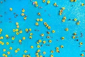 top visie van mensen ontspannende in de zwembad Aan geel opblaasbaar cirkels foto