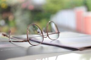 bril Aan tafel, progressief lenzen, bril voor de ouderen, bril progressief lens, lenzenvloeistof progressief lens, detailopname van bril Aan lenzen testen, op zoek door bril foto