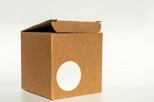 bruin karton doos met circulaire wit sticker Aan een neutrale achtergrond. foto