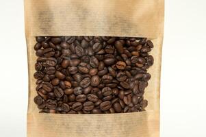 een kraft papier zak met koffie bonen voor viewing met een gemarkeerd schaduw leugens Aan een wit achtergrond foto