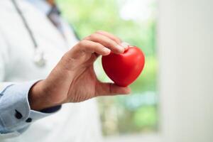 aziatische vrouw arts met rood hart voor gezondheid in het ziekenhuis. foto