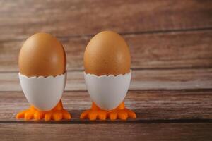 twee vers eieren in een ei kop in de vorm van een kip foto