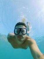 duiker in stofbril en vinnen zwemt naar een diepte onderwater- foto