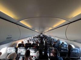 fijn, Griekenland - 20 augustus 2023. rijen van stoelen met passagiers in de cabine van een passagier vliegtuig foto