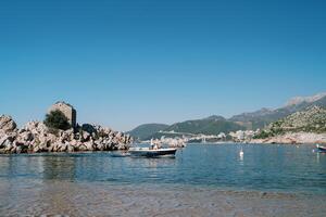 Mens zeilen een visvangst boot Verleden een eiland uit de bergachtig kust. przno, Montenegro foto