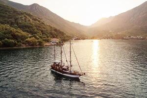 zeilboot zeilen langs de bergachtig kust in de stralen van de zon. dar foto