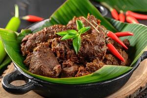 ai gegenereerd rendang rundvlees rijk in specerijen. rendang reeks Aan banaan bladeren. Indonesisch voedsel foto