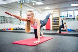 jong vrouw werken uit in de Sportschool het uitvoeren van een oefening voor sterk lichaam en Gezondheid. hoog kwaliteit foto