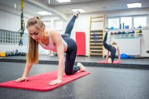 jong vrouw werken uit in de Sportschool het uitvoeren van een oefening voor sterk lichaam en Gezondheid. hoog kwaliteit foto