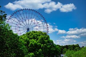 een ferris wiel Bij de park achter de blauw lucht foto