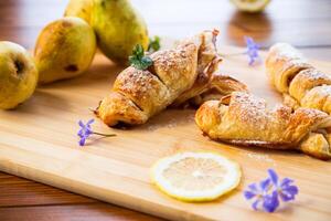 zoet gebakjes, bladerdeeg gebakjes met peren, Aan een houten tafel foto