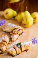 zoet gebakjes, bladerdeeg gebakjes met peren, Aan een houten tafel foto