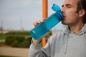 detailopname sportvrouw, mannetje atleet drankjes water naar hydrateren lichaam na buitenshuis cardio training. foto