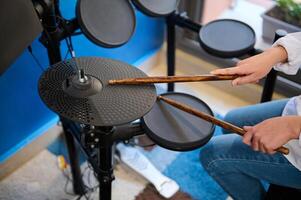 detailopname handen van tiener jongen musicus creëren ritme van muziek- terwijl bonzen drums in elegant retro muziek- studio Bij huis foto