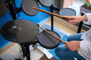 tiener- trommelaar handen. tiener jongen spelen drums in muziek- studio. top visie van jongen musicus slaan Aan de zwart bekkens met drumstokken, het uitvoeren van geluid spelen Aan trommel set. dichtbij omhoog top visie foto