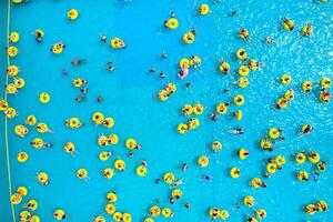 top visie van mensen ontspannende in de zwembad Aan geel opblaasbaar cirkels foto