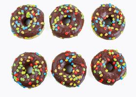reeks van zes smakelijk chocola donuts met smarties Aan wit achtergrond. 6 donut versierd met kleurrijk knabbelen Aan top. verjaardag feest. Chanoeka viering concept. geïsoleerd. top visie foto