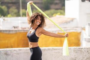 vrouw van middelbare leeftijd met fitnesslichaam aan het trainen op het terras van haar huis foto