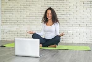 Latijnse vrouw die yoga online geeft foto