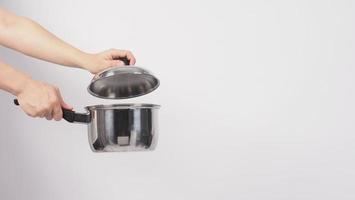 potten schoonmaken. man hand op witte achtergrond die de non-stick pot schoonmaakt foto