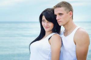 jongen en een meisje in jeans en witte t-shirts op het strand foto