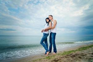 jongen en een meisje in jeans en witte t-shirts op het strand foto