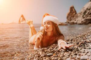 vrouw reizen zee. gelukkig toerist genieten nemen afbeelding Aan de strand voor herinneringen. vrouw reiziger in de kerstman hoed looks Bij camera Aan de zee baai, sharing reizen avontuur reis foto