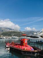 budva, Montenegro - 17 augustus 2023. rood excursie onderzeeër is afgemeerd Bij de pier tegen de backdrop van de bergen foto
