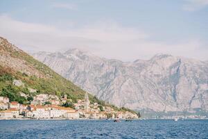 oude huizen van perast Aan de kust van de baai van Kotor met een oude klok toren tegen de backdrop van de bergen. Montenegro foto