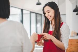 een vrouw met een stralend glimlach ontvangt een rood envelop, een gebaar doordrenkt in cultureel betekenis, overbrengen zegeningen en mooi zo fortuin. foto