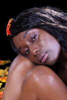 Afrikaanse Amerikaans vrouw hoofd Aan knieën bladeren foto