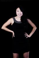 aantrekkelijk jong Japans Amerikaans vrouw staand in zwart jurk foto