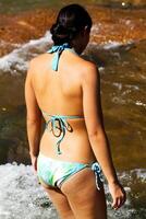 jong vrouw in bikini Bij rivier- van achter foto