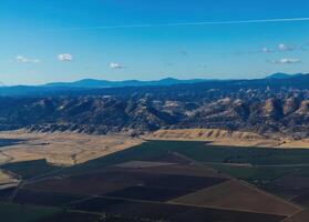 antenne visie van agrarisch velden heuvels bergen blauw lucht foto