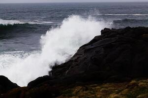 oceaan Golf crashen in vulkanisch rots kust foto