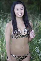 jong Aziatisch Amerikaans vrouw bikini buitenshuis glimlachen foto