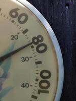 detailopname van wijzerplaat thermometer buitenshuis tegen hek foto