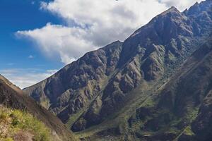 groen robuust Peru heuvels met wit wolken en blauw lucht foto