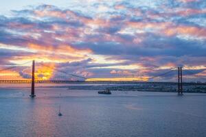 visie van 25 de abril brug over- tagus rivier- Aan zonsondergang. Lissabon, Portugal foto